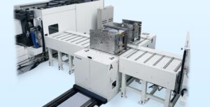 Pascal powered drive roller mold changer carrying a 4-ton mold beside a 4,500 kN injection molding machine